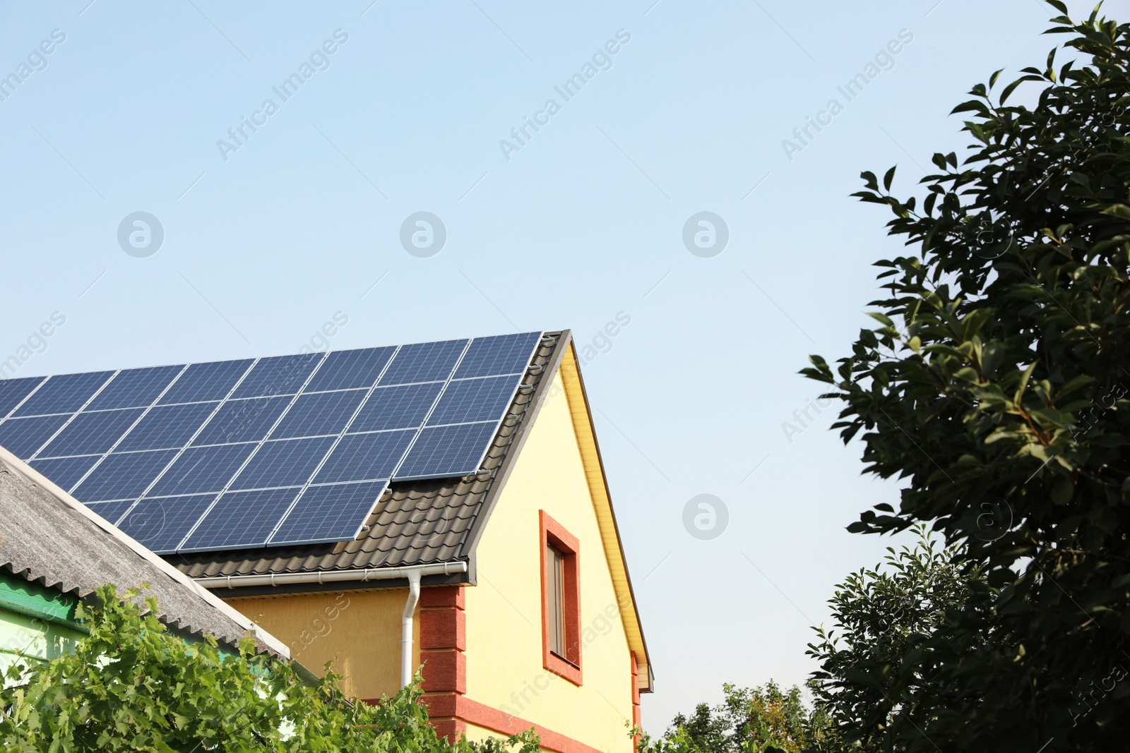 House with installed solar panels on roof. Alternative energy source Photo of House with installed solar panels on roof. Alternative energy source
