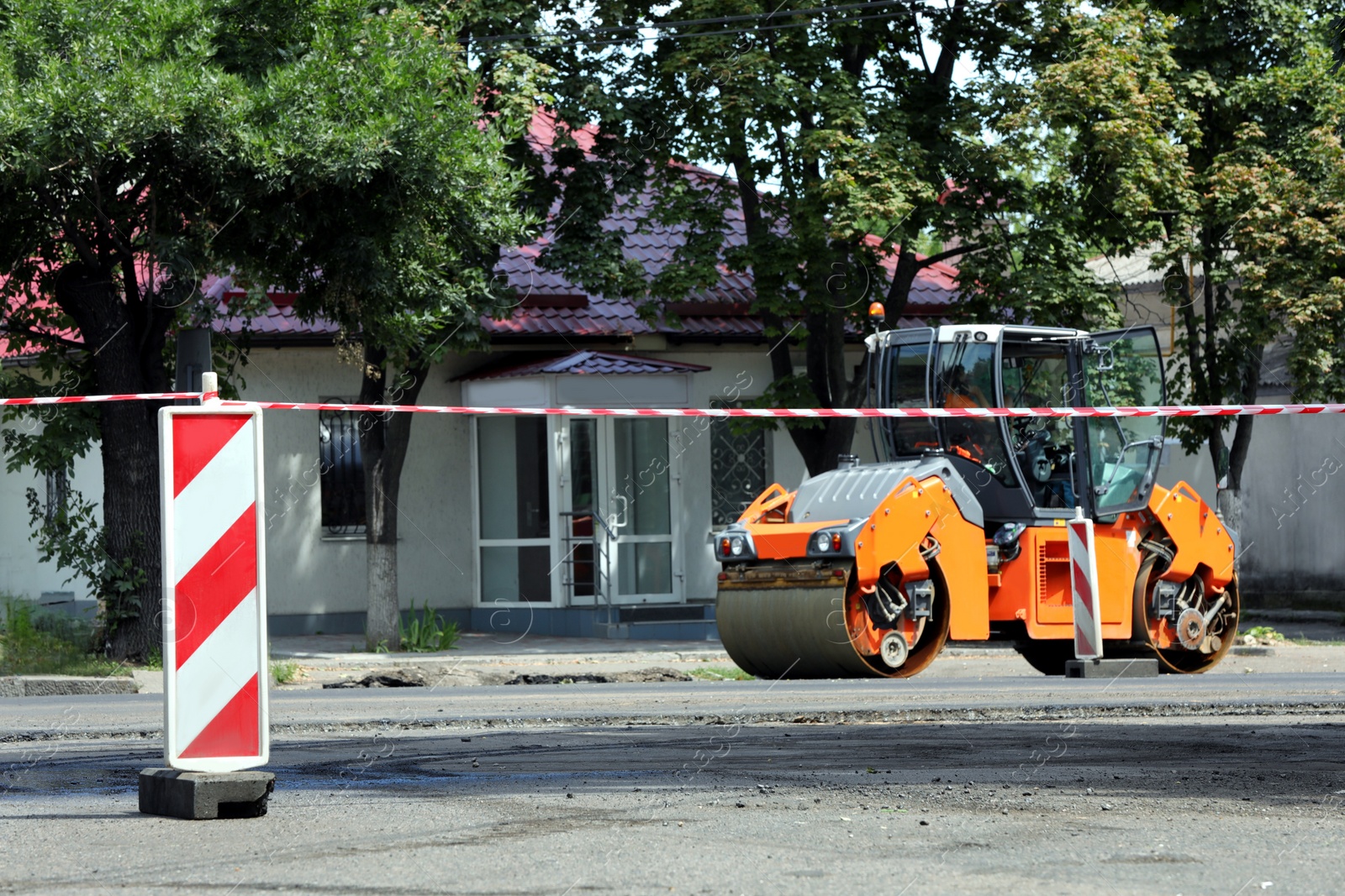 Modern roller working on city street. Road repair Photo of Modern roller working on city street. Road repair