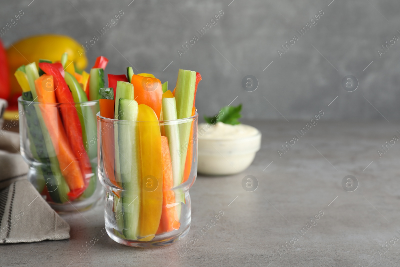 Different vegetables cut in sticks on light grey table. Space for text Photo of Different vegetables cut in sticks on light grey table. Space for text