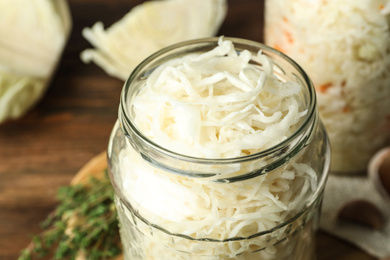 Jar of tasty fermented cabbage on table, closeup Photo of Jar of tasty fermented cabbage on table, closeup