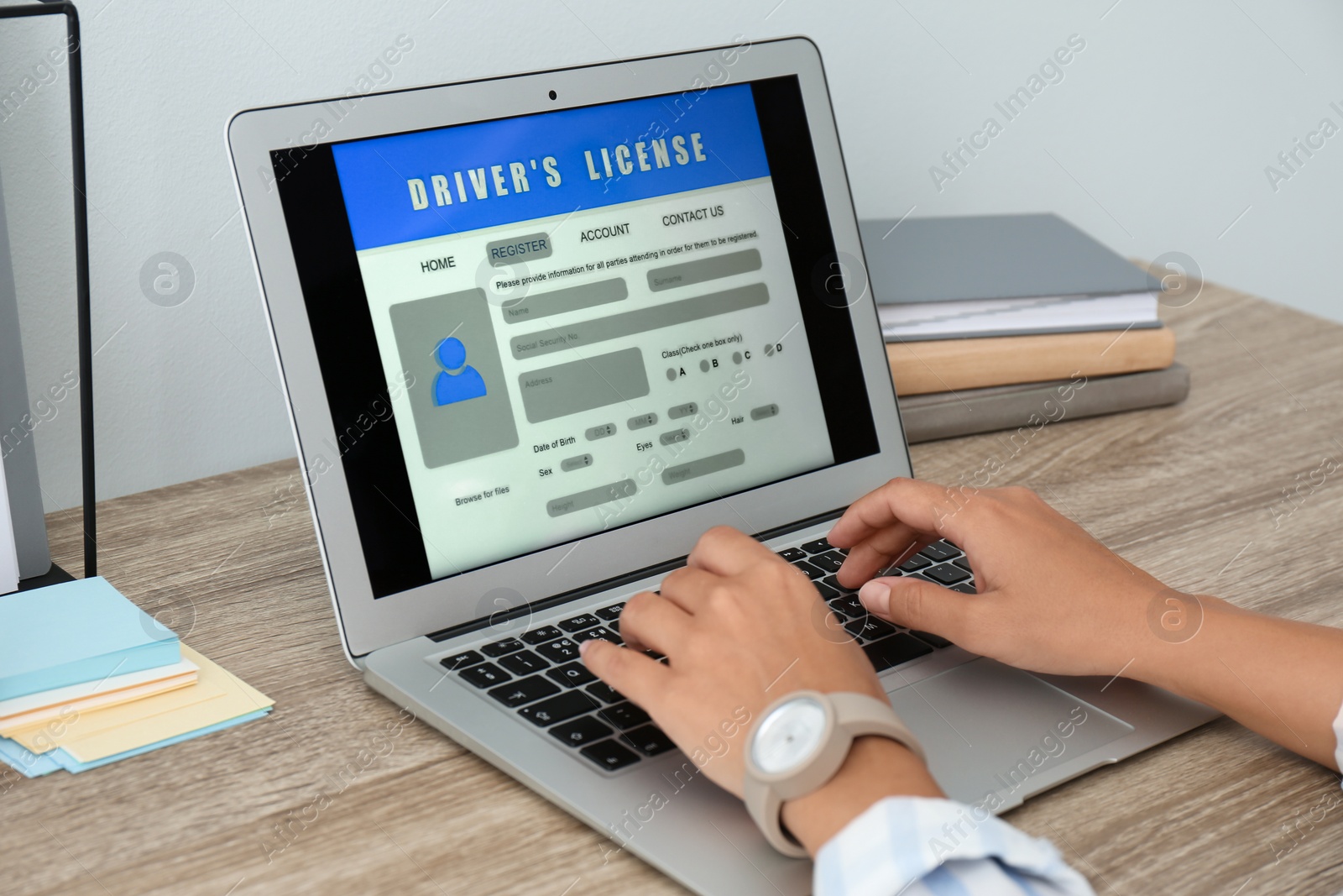 Woman using laptop to fill driver's license application form at table in office, closeup Photo of Woman using laptop to fill driver's license application form at table in office, closeup