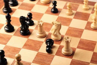 Wooden chessboard with game pieces as background Photo of Wooden chessboard with game pieces as background