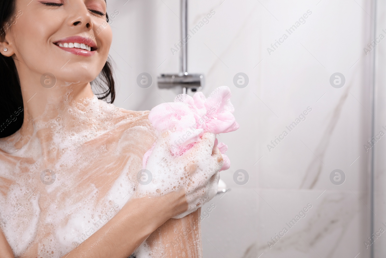 Young woman with mesh pouf taking shower at home. Space for text Photo of Young woman with mesh pouf taking shower at home. Space for text