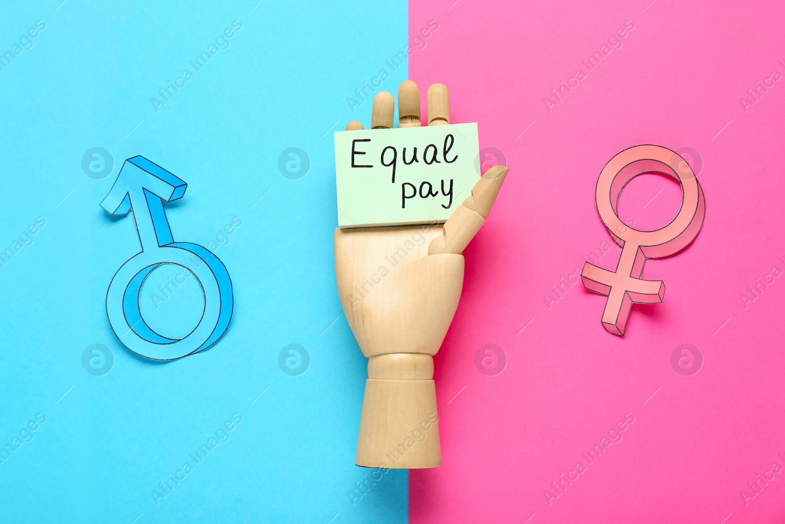 Gender pay gap. Wooden mannequin hand with paper note, male and female symbols on color background, flat lay Photo of Gender pay gap. Wooden mannequin hand with paper note, male and female symbols on color background, flat lay