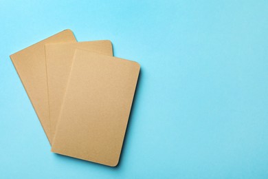 Stylish kraft planners on light blue background, flat lay. Space for text Photo of Stylish kraft planners on light blue background, flat lay. Space for text