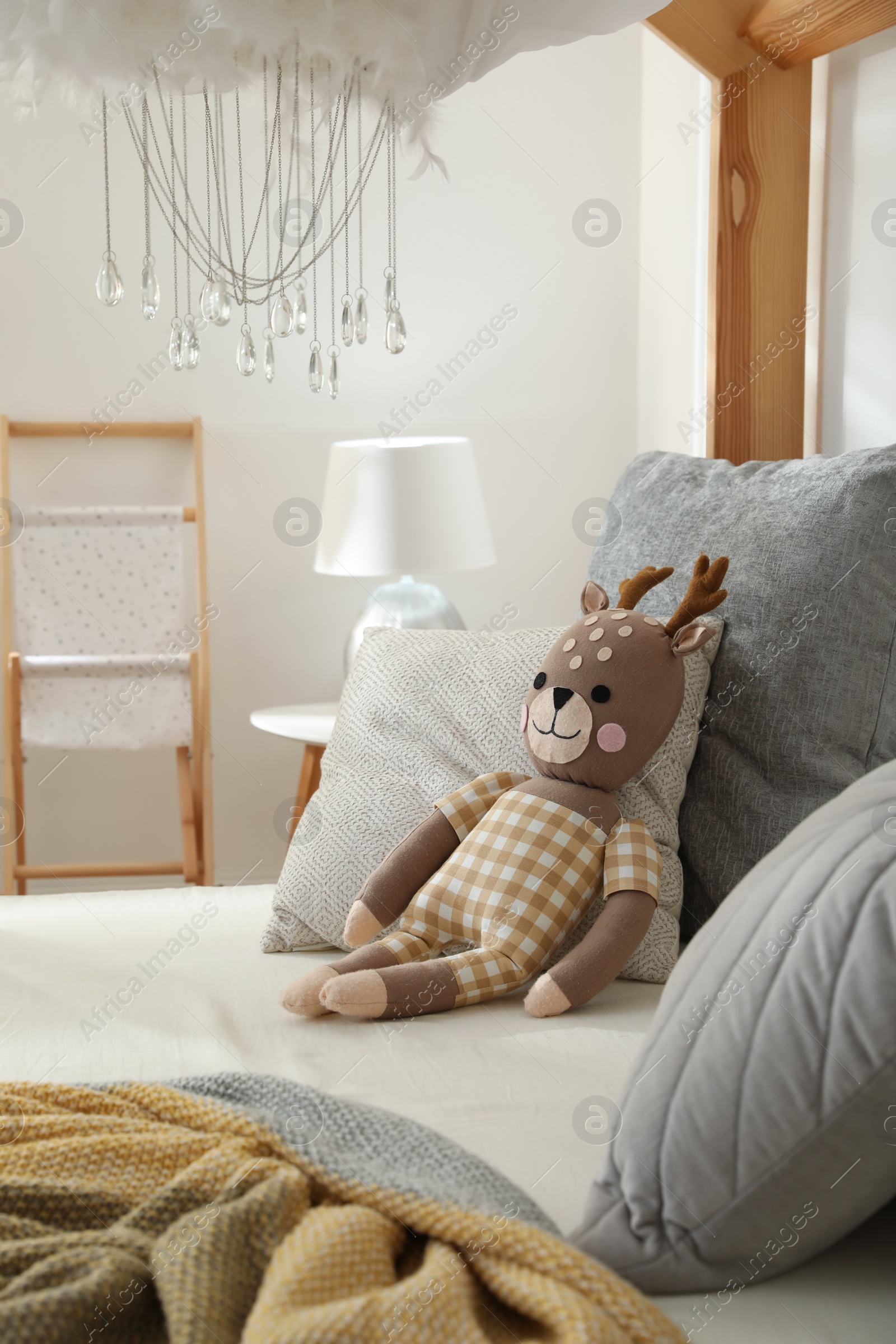 Comfortable wooden house bed with cushions and toy in child room. Interior design Photo of Comfortable wooden house bed with cushions and toy in child room. Interior design