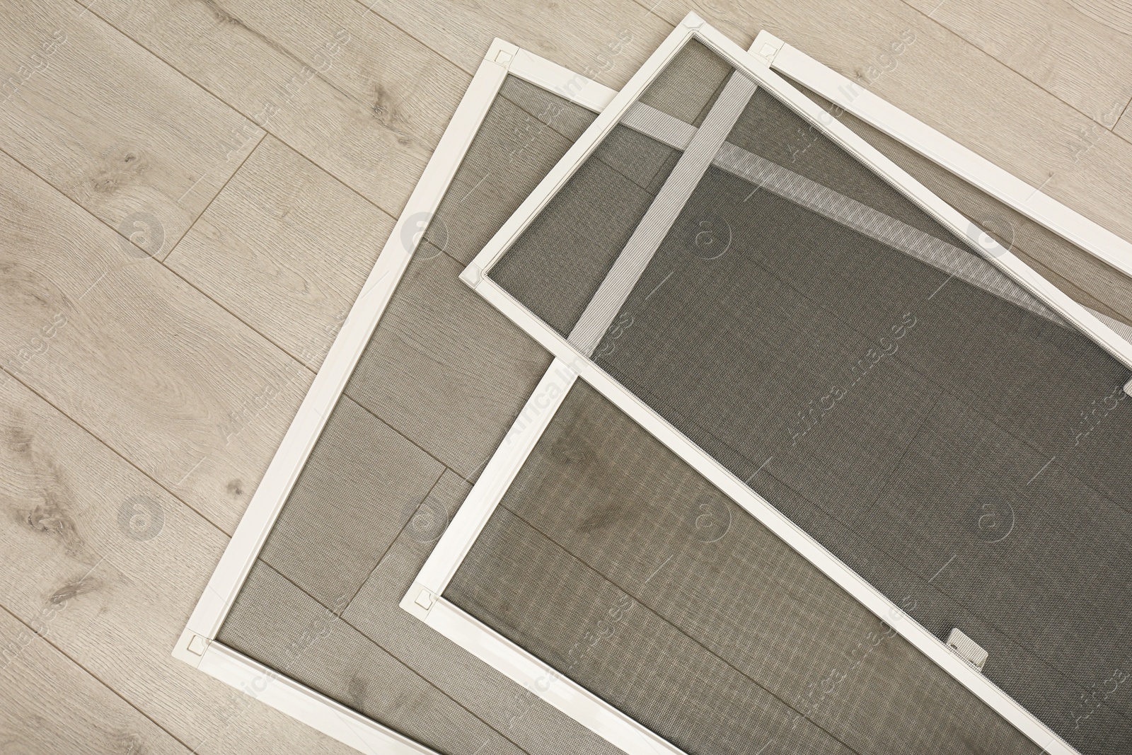 Set of window screens on wooden floor, flat lay Photo of Set of window screens on wooden floor, flat lay