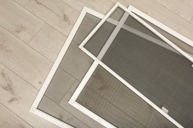 Set of window screens on wooden floor, flat lay Photo of Set of window screens on wooden floor, flat lay