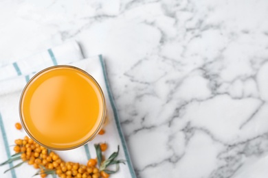 Delicious sea buckthorn juice on white marble table, top view. Space for text Photo of Delicious sea buckthorn juice on white marble table, top view. Space for text