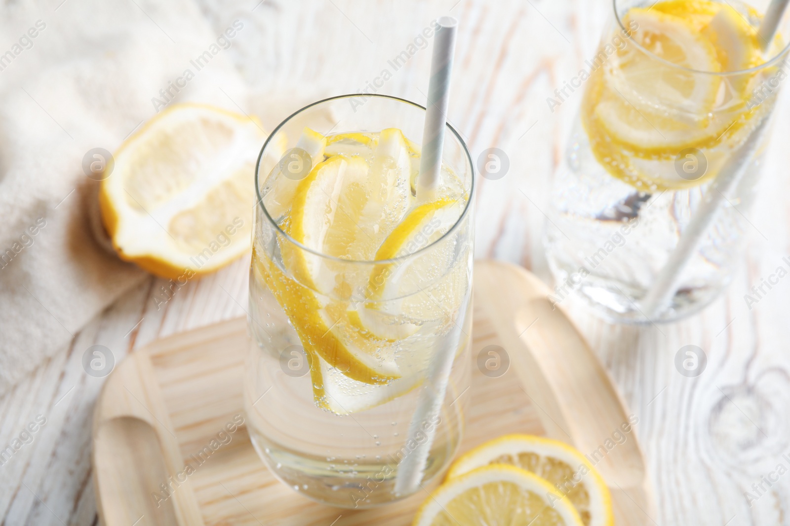 Soda water with lemon slices and fresh fruits on white wooden table Photo of Soda water with lemon slices and fresh fruits on white wooden table