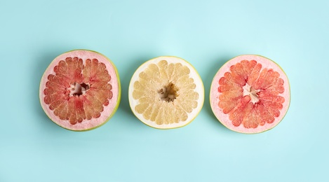 Fresh cut pomelo fruits on light blue background, flat lay Photo of Fresh cut pomelo fruits on light blue background, flat lay