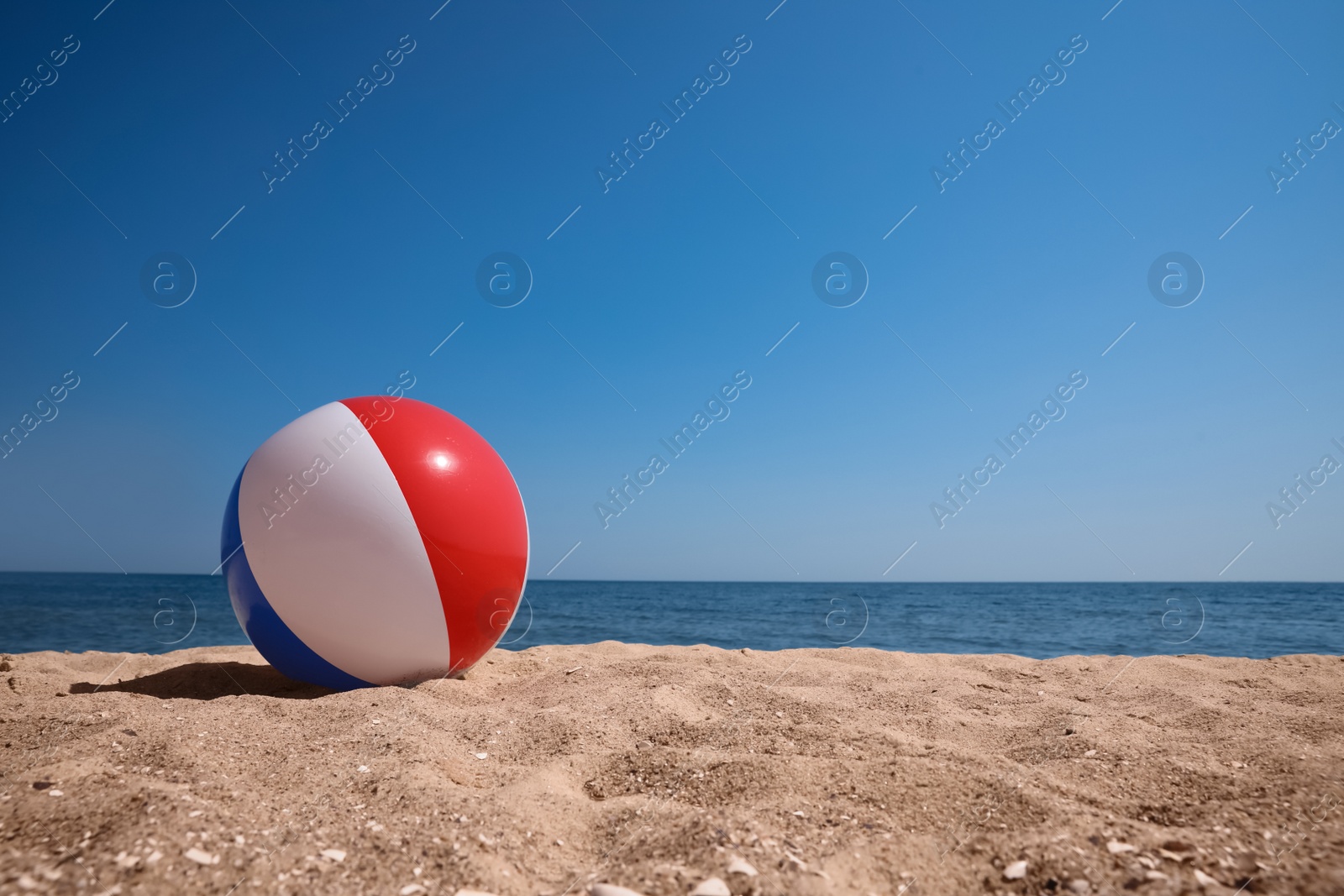 Colorful inflatable ball on sandy beach. Space for text Photo of Colorful inflatable ball on sandy beach. Space for text