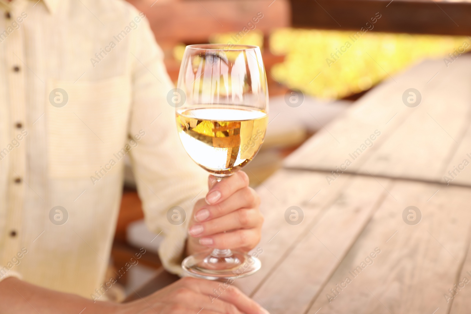 Woman with glass of white wine in outdoor cafe, closeup Photo of Woman with glass of white wine in outdoor cafe, closeup