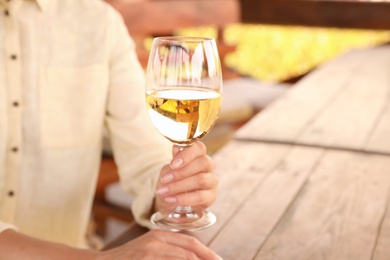Woman with glass of white wine in outdoor cafe, closeup Photo of Woman with glass of white wine in outdoor cafe, closeup