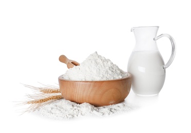 Wheat flour and jug of milk on white background Photo of Wheat flour and jug of milk on white background