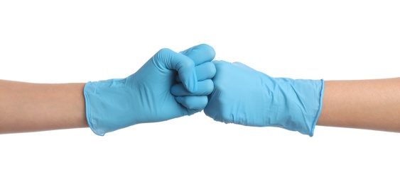 Doctors in medical gloves making fist bump on white background, closeup Photo of Doctors in medical gloves making fist bump on white background, closeup