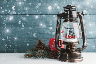 Beautiful Christmas snow globe in vintage lantern on light blue wooden background, bokeh effect. Space for text Image of Beautiful Christmas snow globe in vintage lantern on light blue wooden background, bokeh effect. Space for text