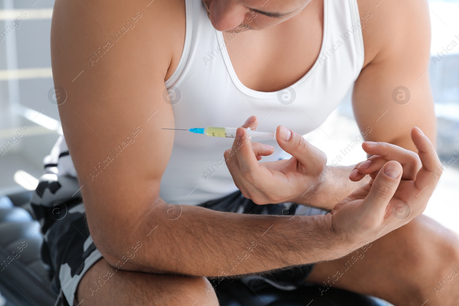 Sportsman injecting himself indoors, closeup. Doping concept Photo of Sportsman injecting himself indoors, closeup. Doping concept