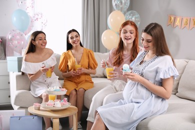 Happy pregnant woman spending time with friends at baby shower party Photo of Happy pregnant woman spending time with friends at baby shower party