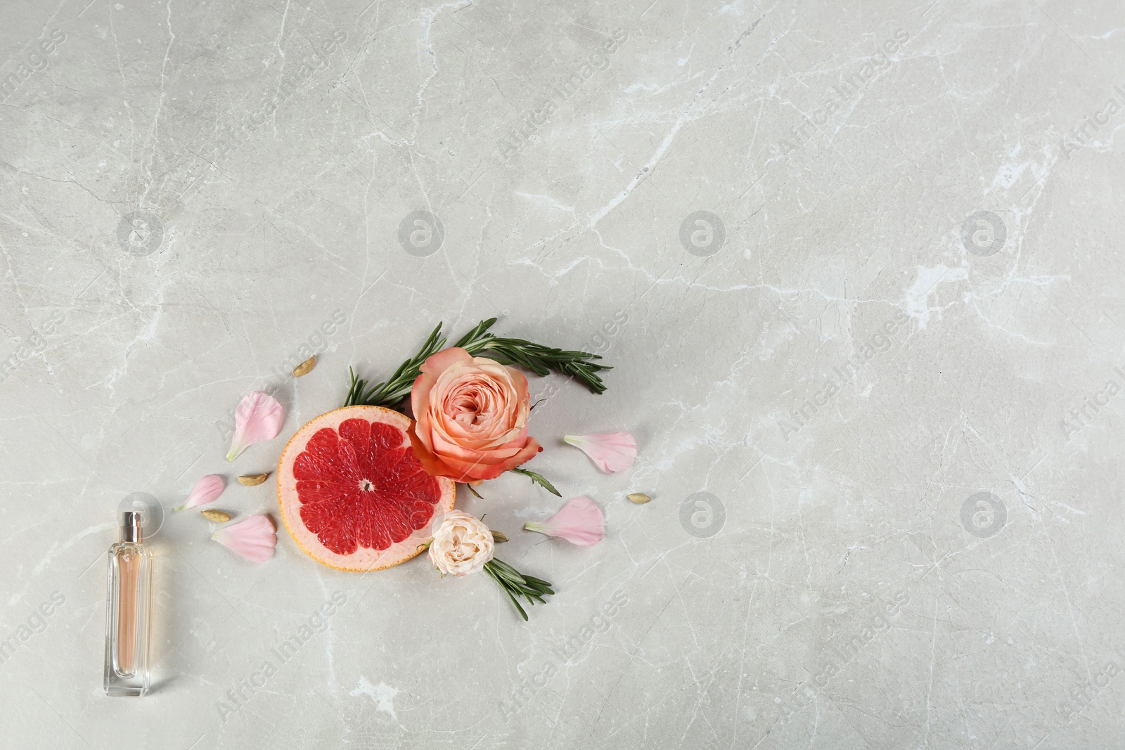 Photo of Flat lay composition with bottle of perfume on marble background, space for text