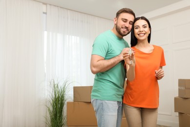 Photo of Happy young couple with key in new house. Space for text