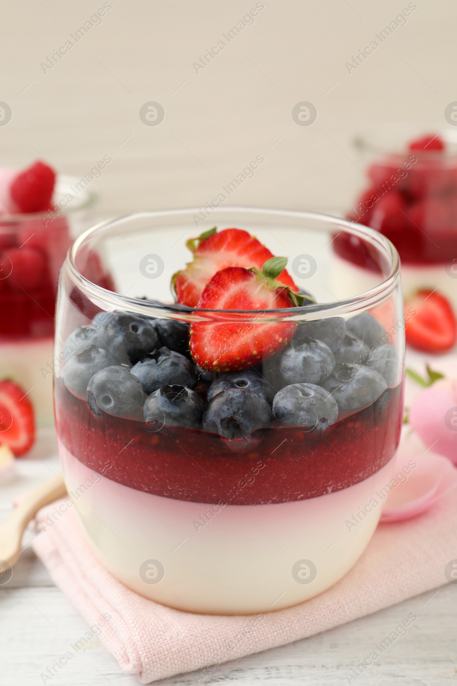 Delicious panna cotta with berries on white table Photo of Delicious panna cotta with berries on white table