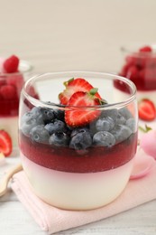 Delicious panna cotta with berries on white table Photo of Delicious panna cotta with berries on white table
