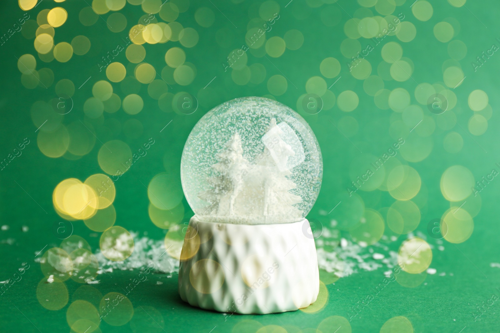 Beautiful Christmas snow globe on green background, bokeh effect Image of Beautiful Christmas snow globe on green background, bokeh effect