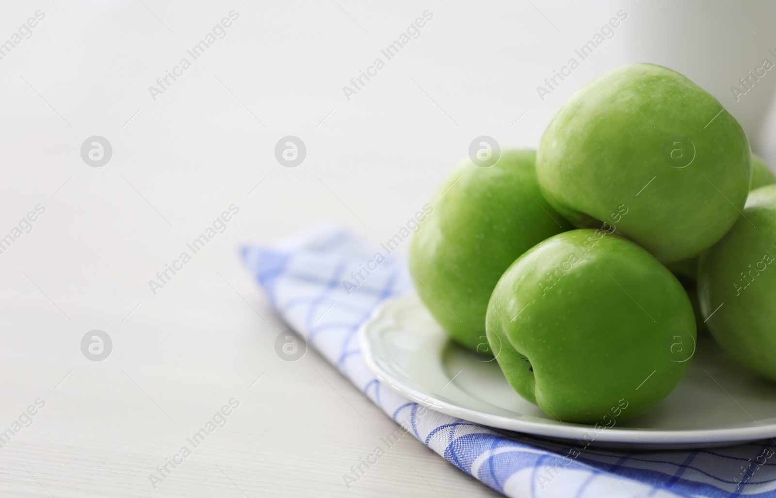 Plate with ripe green apples on table Photo of Plate with ripe green apples on table