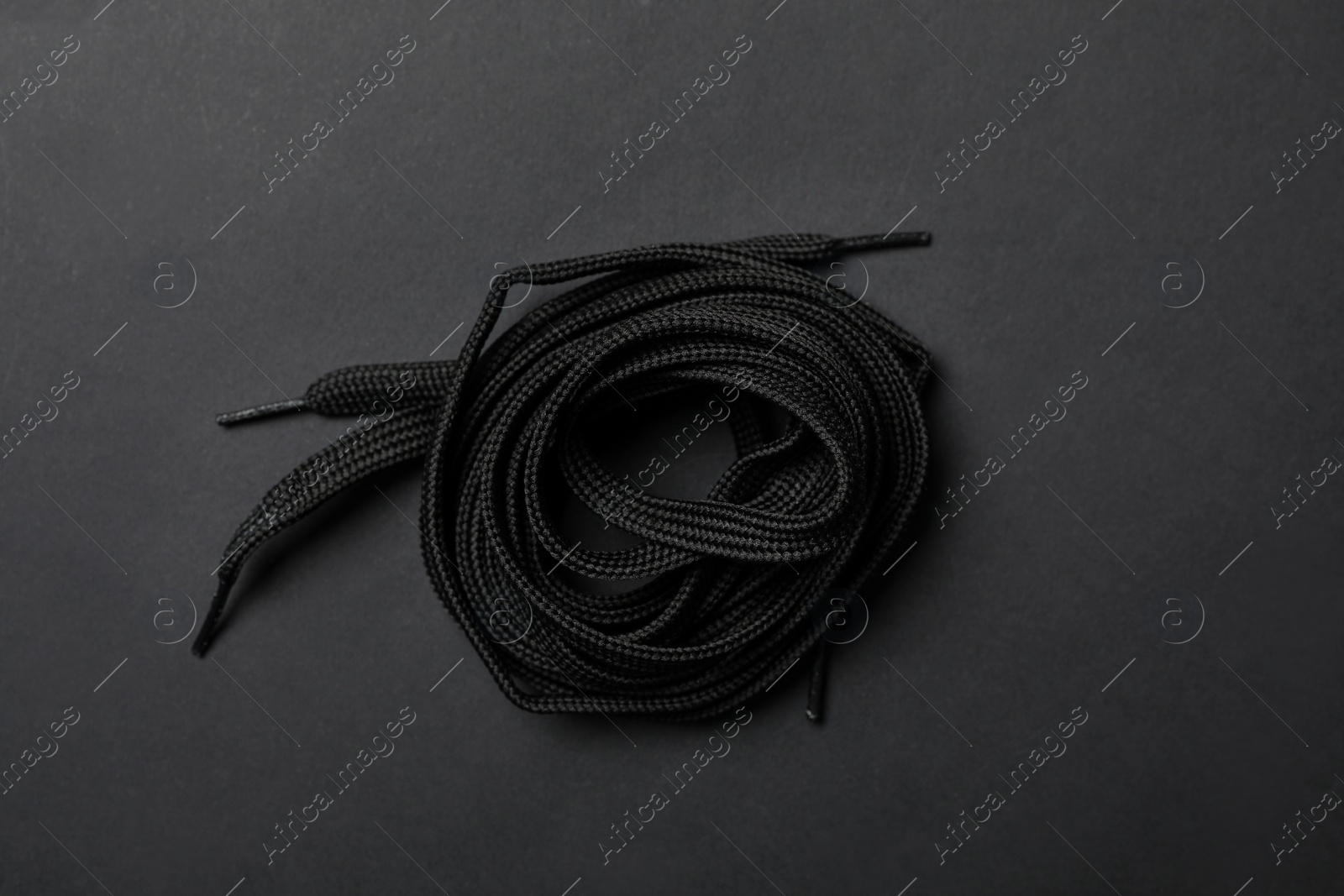 Shoelaces on black background, top view. Stylish accessory Photo of Shoelaces on black background, top view. Stylish accessory