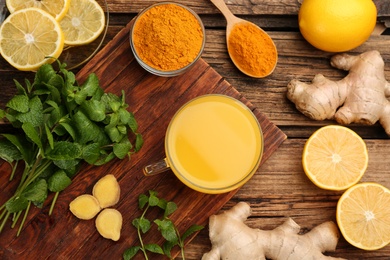 Flat lay composition with immunity boosting drink and ingredients on wooden table Photo of Flat lay composition with immunity boosting drink and ingredients on wooden table
