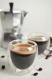 Tasty coffee and beans on white wooden table Photo of Tasty coffee and beans on white wooden table
