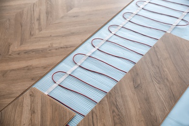 Installation of modern underfloor trace heating system indoors Photo of Installation of modern underfloor trace heating system indoors