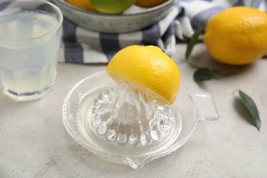 Glass squeezer with lemon and juice on light table, closeup Photo of Glass squeezer with lemon and juice on light table, closeup