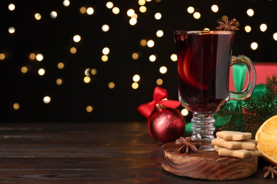 Christmas composition with cup of mulled wine on wooden table. Space for text Photo of Christmas composition with cup of mulled wine on wooden table. Space for text
