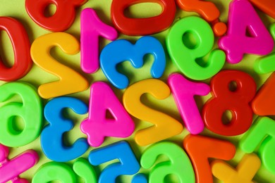 Colorful magnetic numbers on light green background, flat lay Photo of Colorful magnetic numbers on light green background, flat lay