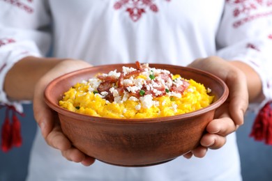 Woman holding bowl of banosh with brynza and pork cracklings, closeup. Traditional Ukrainian dish Photo of Woman holding bowl of banosh with brynza and pork cracklings, closeup. Traditional Ukrainian dish