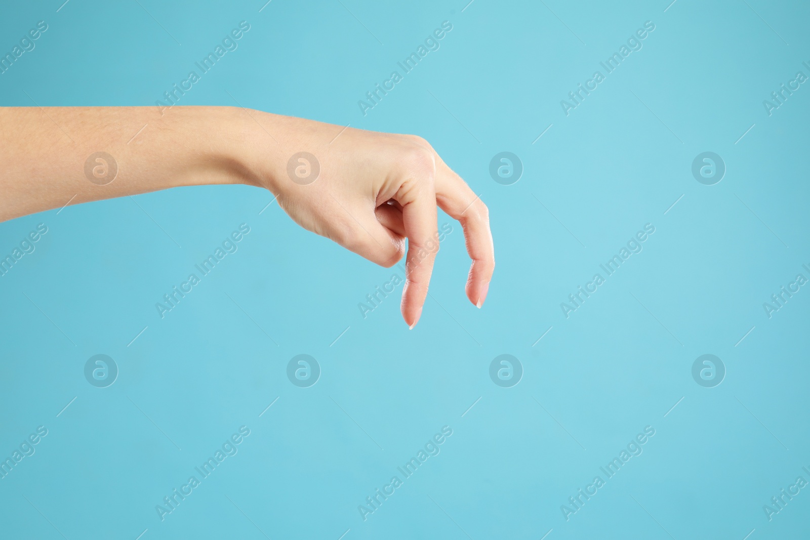 Woman imitating walk with hand on light blue background, closeup. Finger gesture Photo of Woman imitating walk with hand on light blue background, closeup. Finger gesture