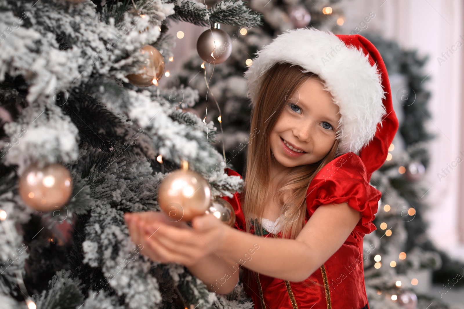Photo of Cute little child near Christmas tree at home