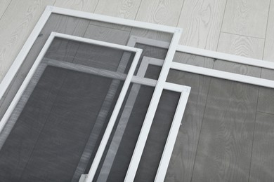 Set of window screens on wooden floor, above view Photo of Set of window screens on wooden floor, above view
