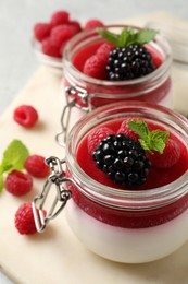 Delicious panna cotta with fruit coulis and fresh berries on table, closeup Photo of Delicious panna cotta with fruit coulis and fresh berries on table, closeup