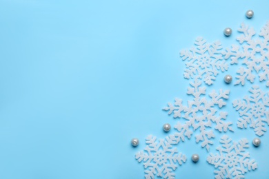 Beautiful decorative snowflakes on light blue background, flat lay. Space for text Photo of Beautiful decorative snowflakes on light blue background, flat lay. Space for text