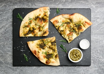 Delicious focaccia bread with green olives on grey table, flat lay Photo of Delicious focaccia bread with green olives on grey table, flat lay