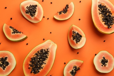 Fresh ripe papaya fruits on orange background, flat lay Photo of Fresh ripe papaya fruits on orange background, flat lay