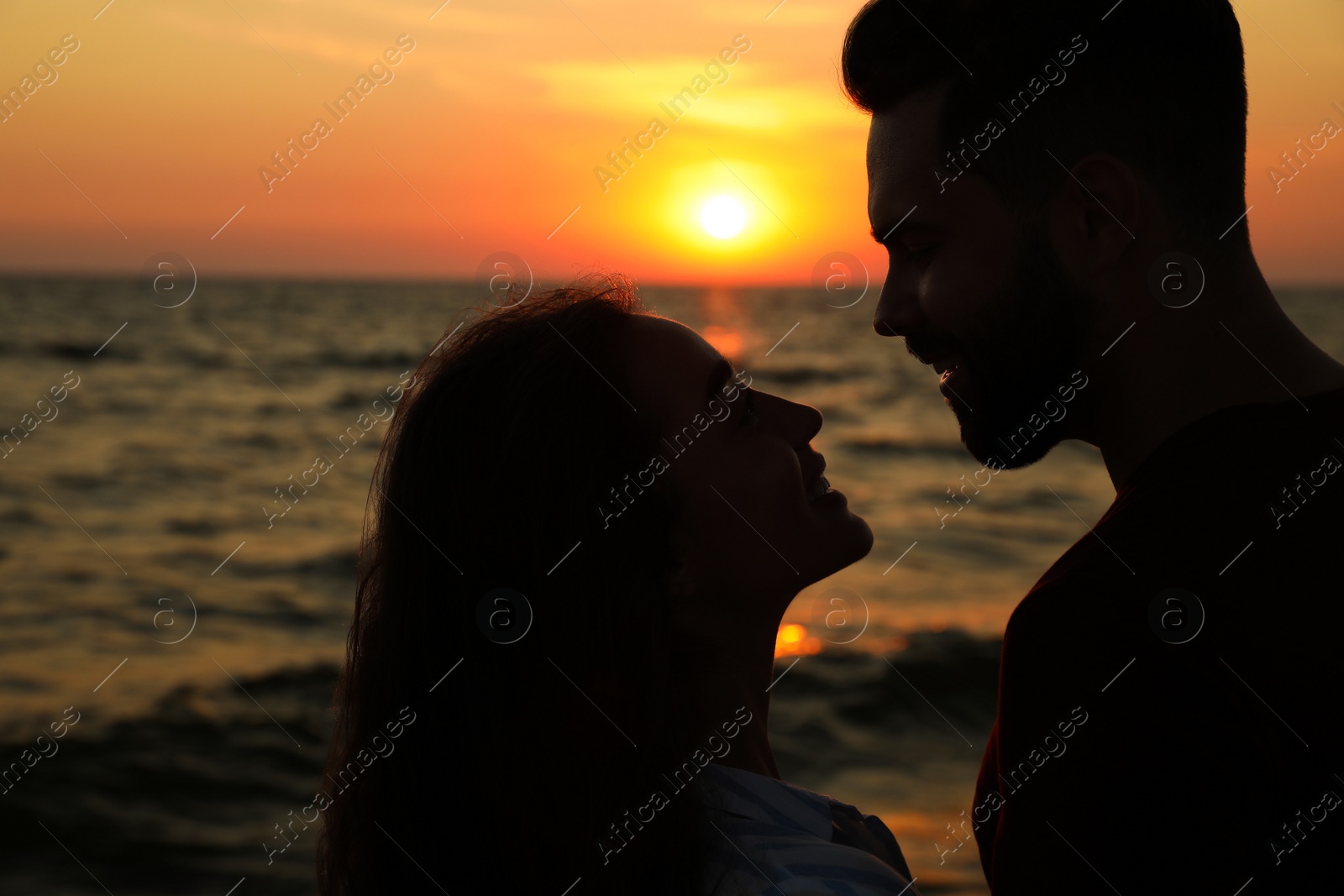Couple spending time together on beach at sunset Photo of Couple spending time together on beach at sunset
