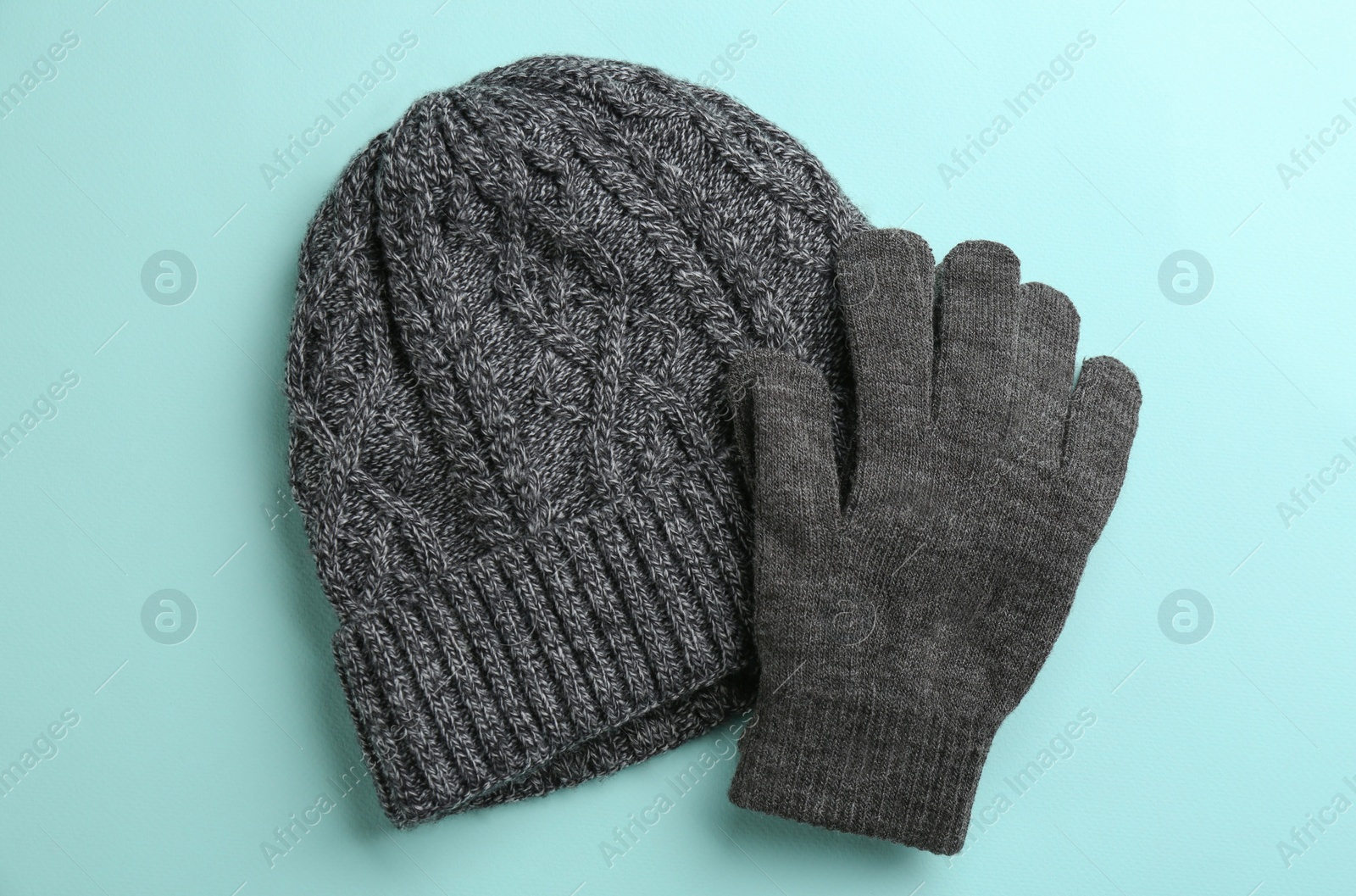 Woolen gloves and hat on light blue background, flat lay Photo of Woolen gloves and hat on light blue background, flat lay