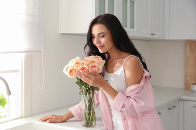 Young woman with beautiful bouquet in kitchen Photo of Young woman with beautiful bouquet in kitchen