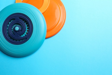 Plastic frisbee disks and ring on light blue background, flat lay. Space for text Photo of Plastic frisbee disks and ring on light blue background, flat lay. Space for text