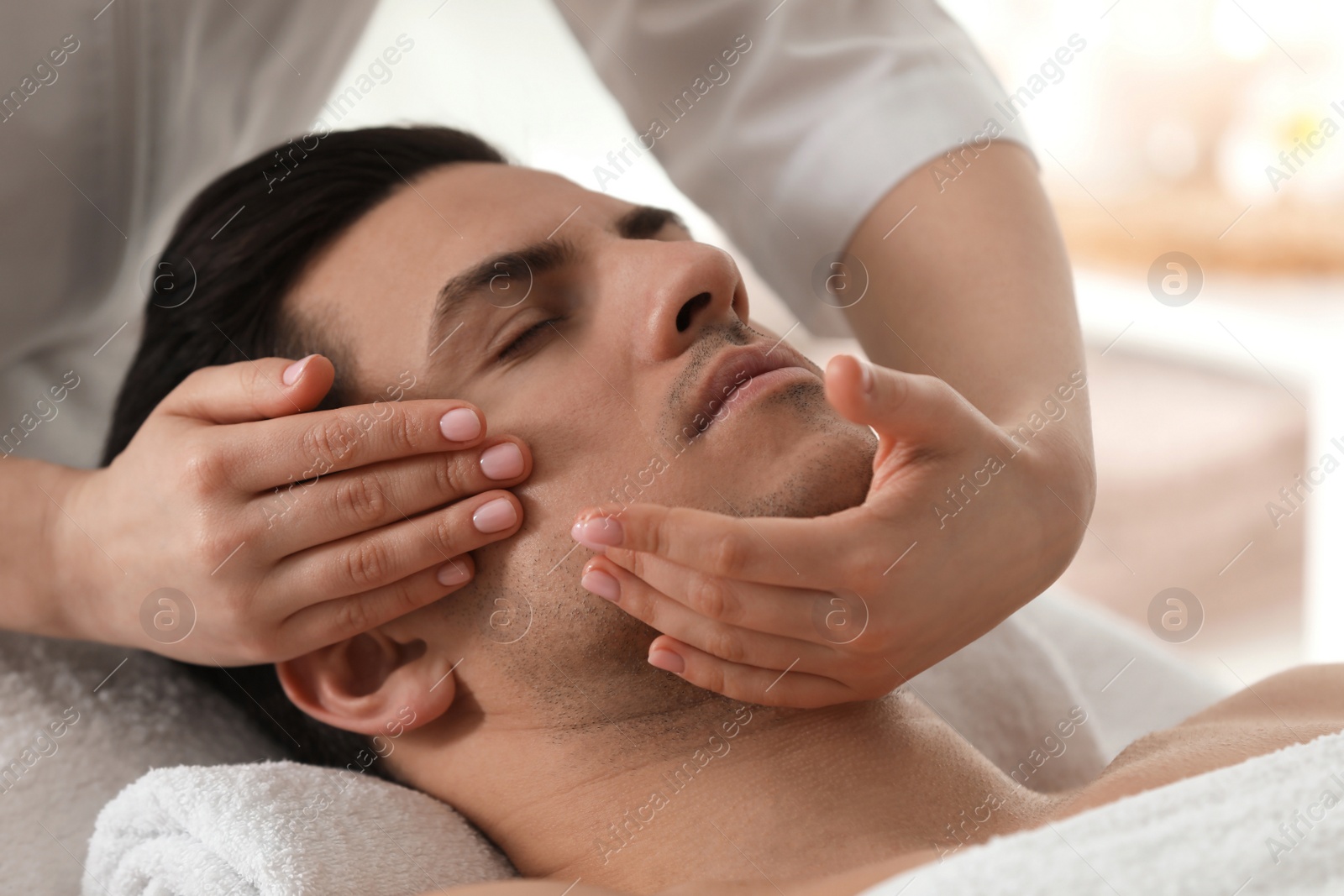 Man receiving facial massage in beauty salon, closeup Photo of Man receiving facial massage in beauty salon, closeup