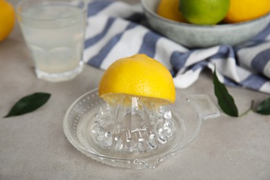 Glass squeezer with lemon and juice on light table, closeup Photo of Glass squeezer with lemon and juice on light table, closeup